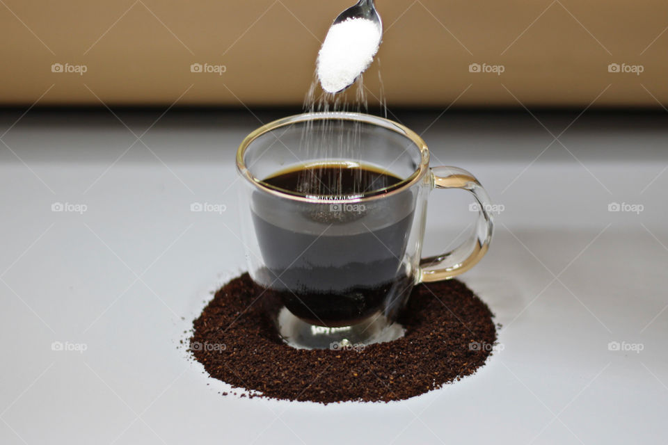 Sugar being poured into Coffee