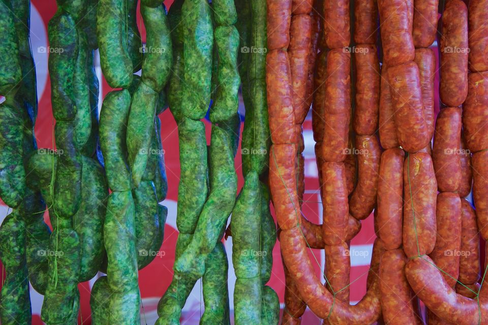 Green and red chorizos (sausages) from Toluca, Mexico are on display for sale at an outdoor market.