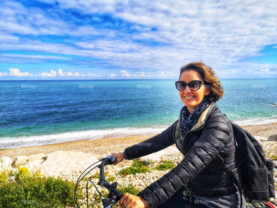 smiling woman rides a bicycle to keep fit