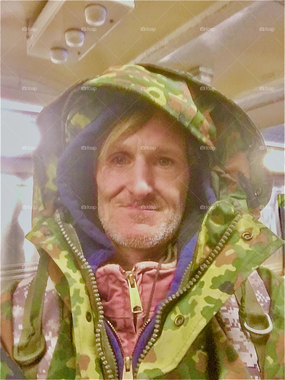 Timothy Trespas aboard our boat, the “Salvation” in the waters of the East River at Newtown Creek in Long Island City, Queens, NY about to step out wearing a warm military fatigue winter coat. 2021. Hypnotic Productions