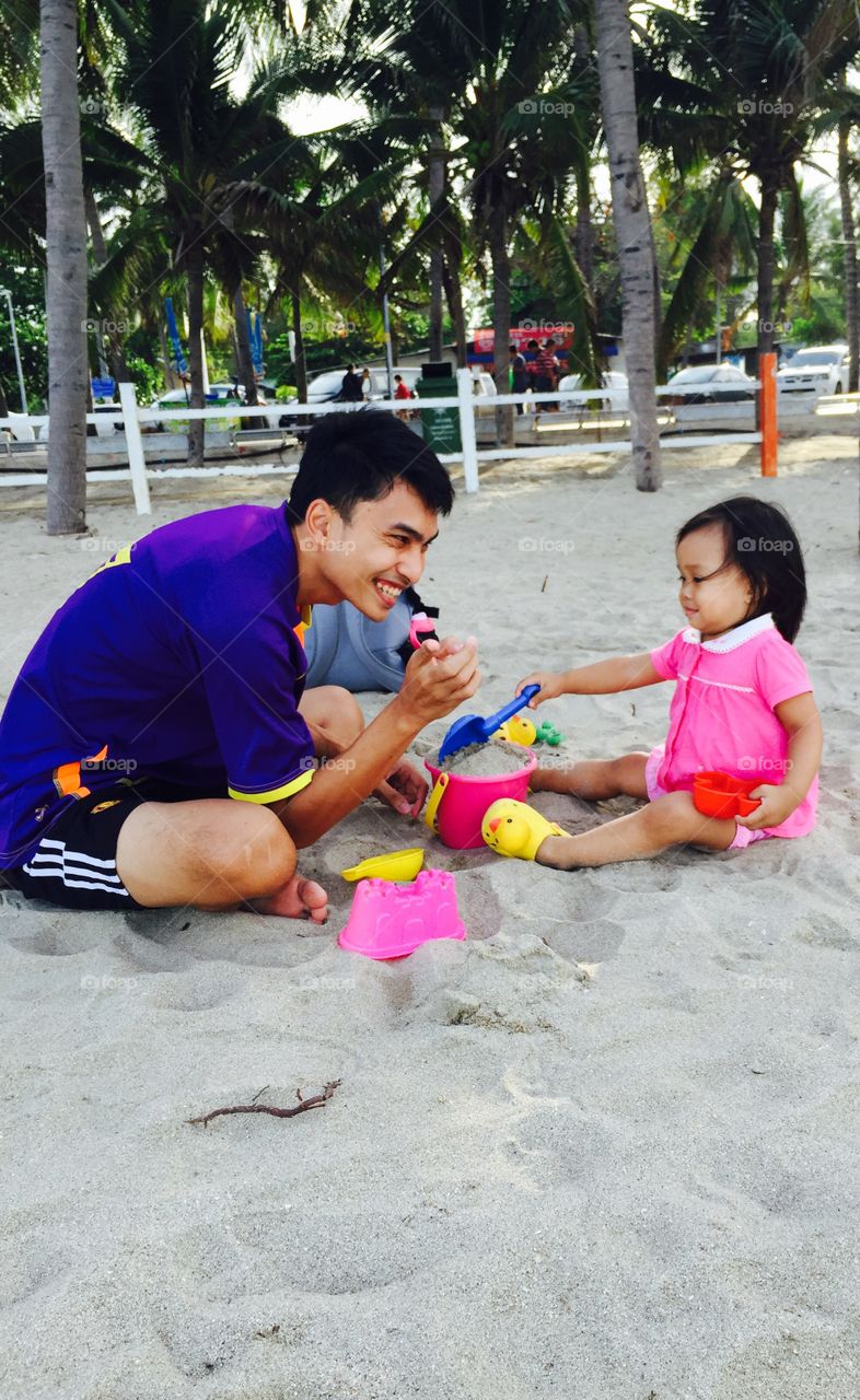 Dad and daughter had very funny with play sand on the beach