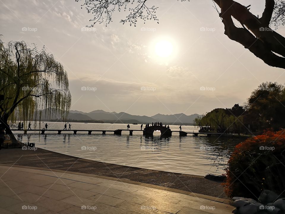 Nature of China.  Sunset over lake Xihu. Xihu is a famous freshwater lake in the center of the city of Hangzhou and it is considered to be one of the most beautiful places in China.
Place: China,  Zhejiang province,  Hangzhou. 
Date: 2019/03/26