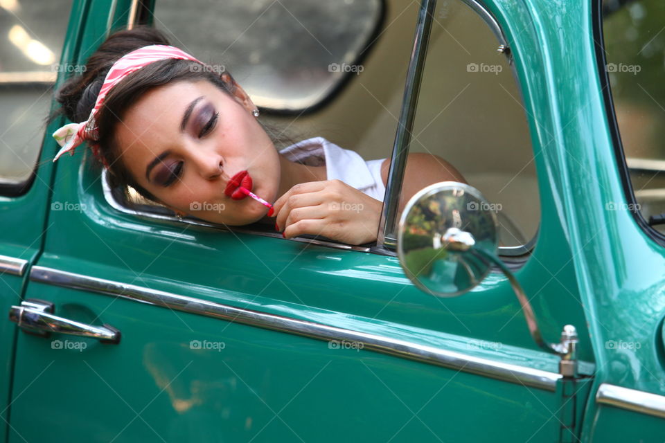 Lollipop and a cute girl. Cute girl out of a car window licking lollipop