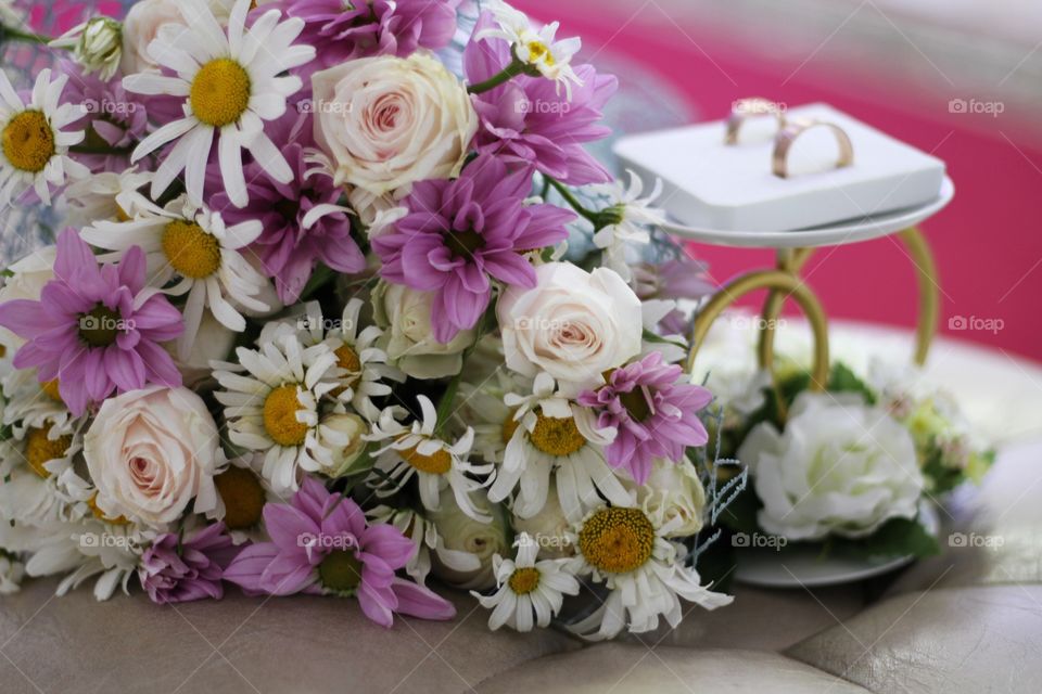 wedding bouquet of daisies, roses and chrysanthemums on the background of rings