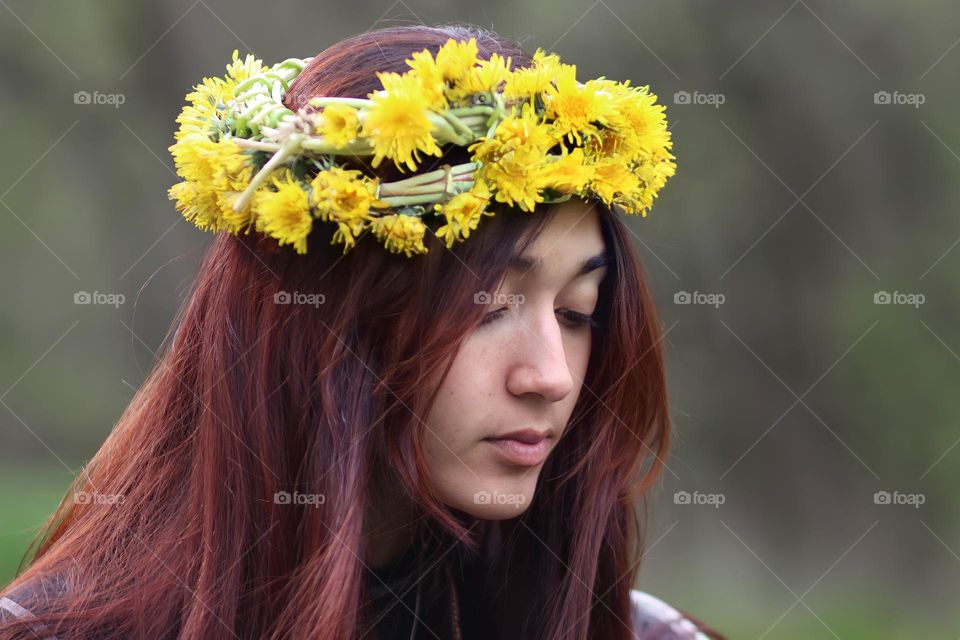 Portrait of a Beautiful young woman in a dandelion wreath