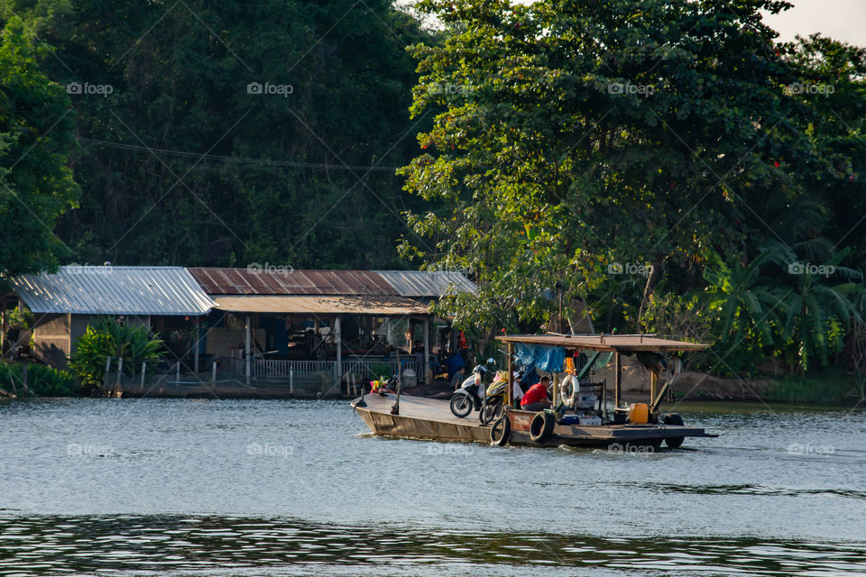 Ship passenger and motorbikes across  Khwae Noi river at Kanchanaburi Thailand.