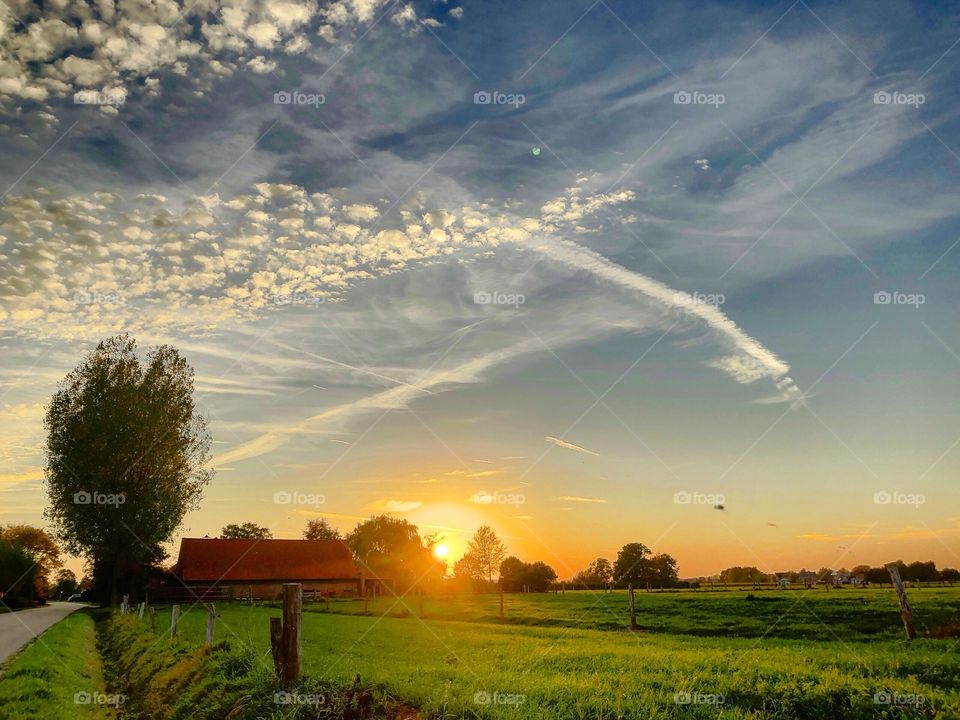 Idyllic Countryside sunset with clouds painted in the dramatic and colorful sky