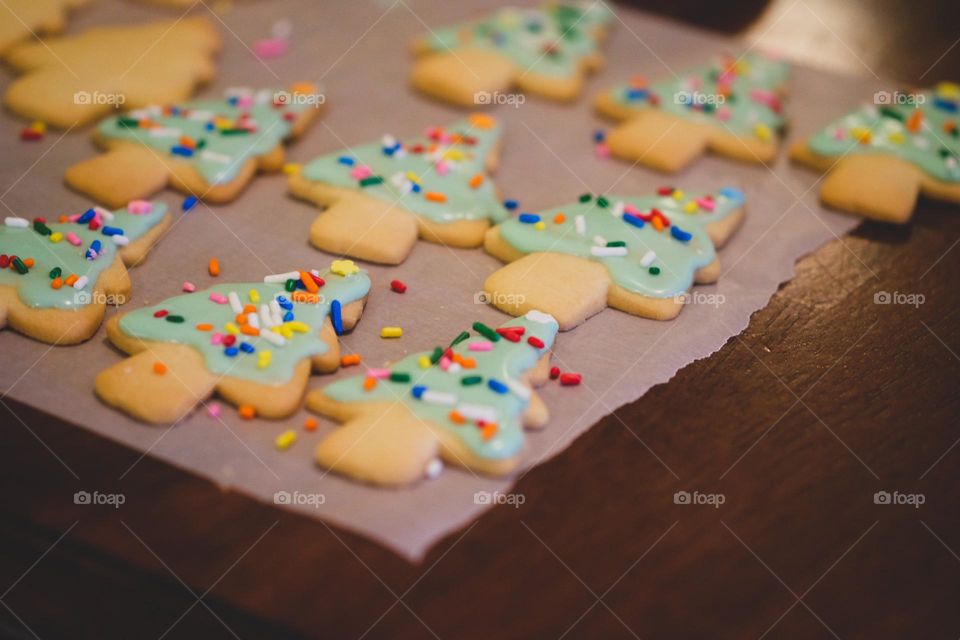 Holiday sugar cookies laying out to cool, holiday sugar cookies, Christmas tree cookies decorated, sprinkles and frosting on Christmas tree sugar cookies 