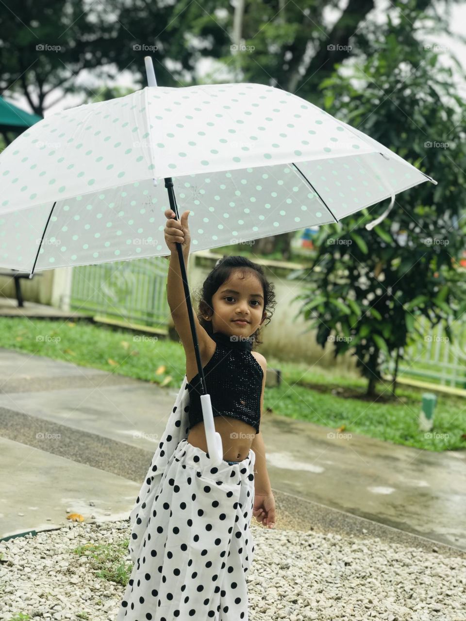 Beautiful girl in polka dots dress along with polka dot umbrella 