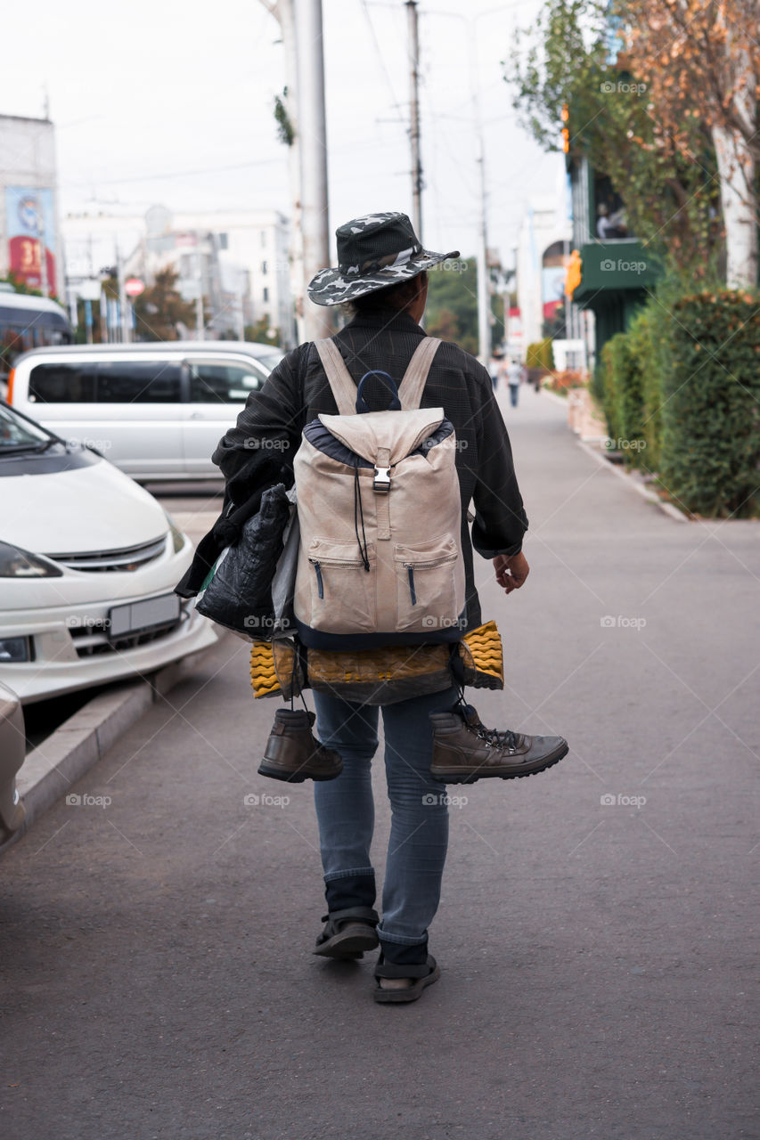 Traveler back view . Backpack with boots.