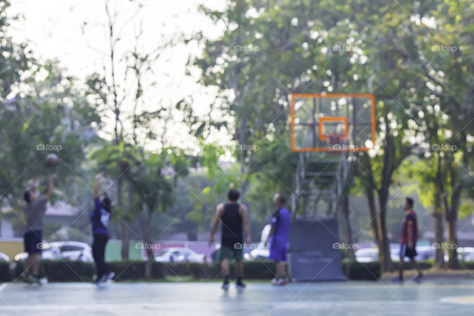 Blurry image of elderly men and women playing basketball in the morning.
