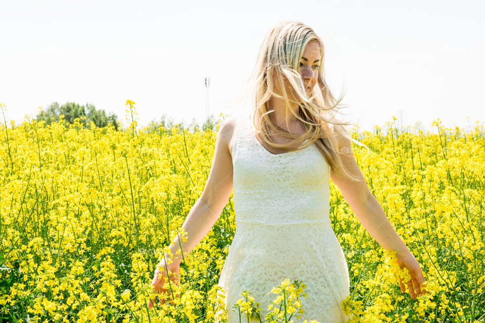 Woman posing in yellow flower field