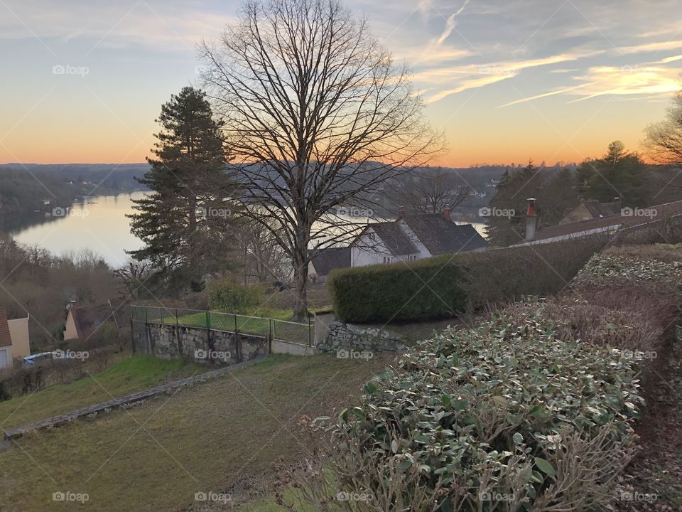 A view of rural France in the winter, the sun is setting and a body of water can be seen in the distance - no edits, #nofilter, true nature, #truephotos