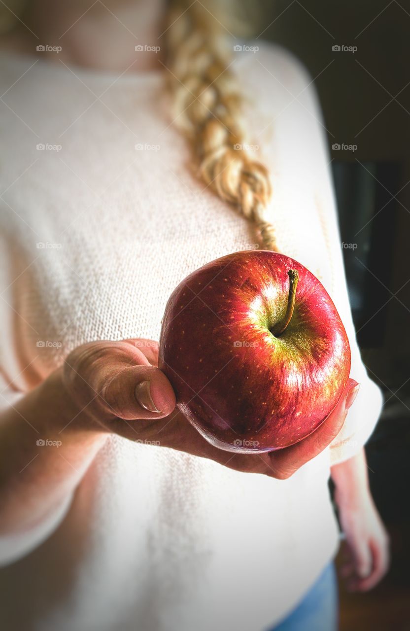 Woman's hand holding out apple