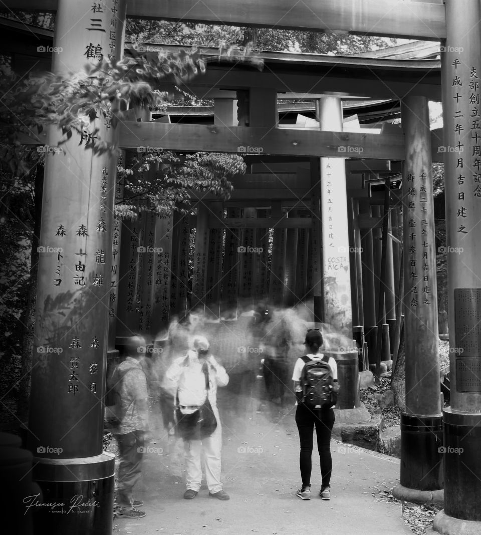 People walking through Tori gates in Kyoto - Japan