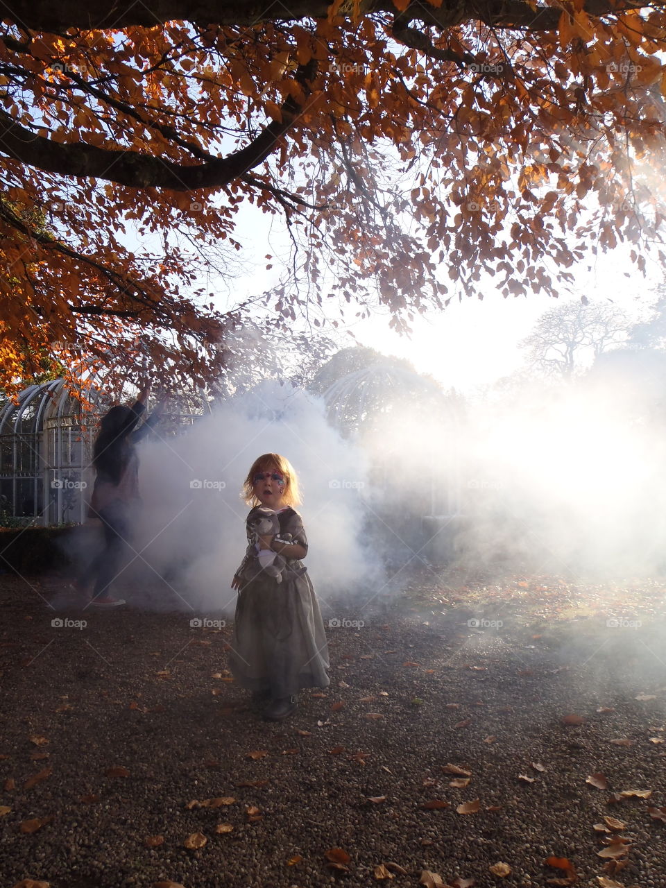 Cute girl standing under tree during autumn