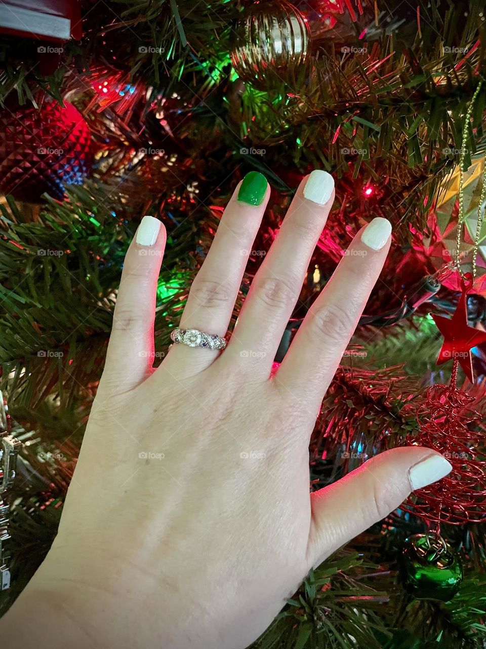 White and green nails with a Christmas tree background