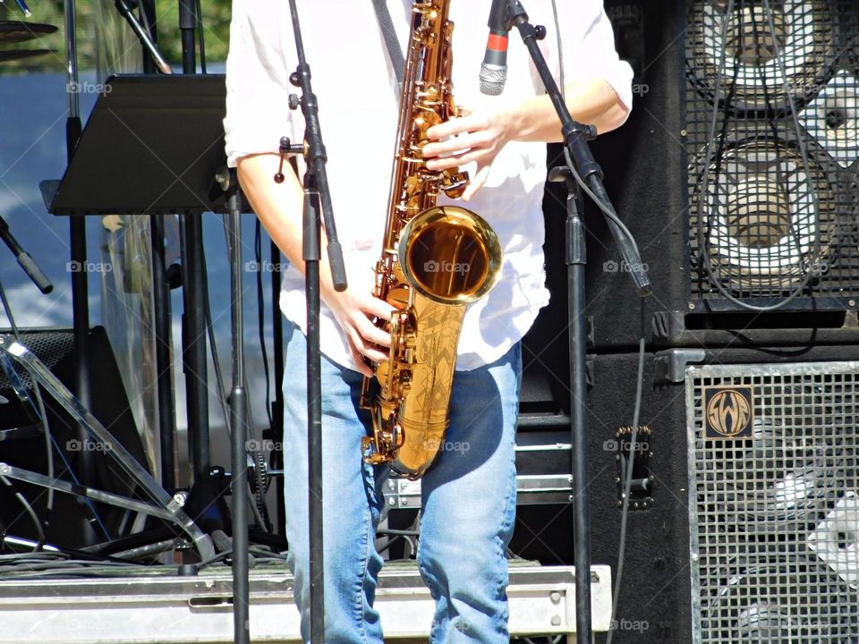 Playing an Instrument - In action with his Saxophone - A person who plays or uses a musical instrument as their hobby or job, is musician