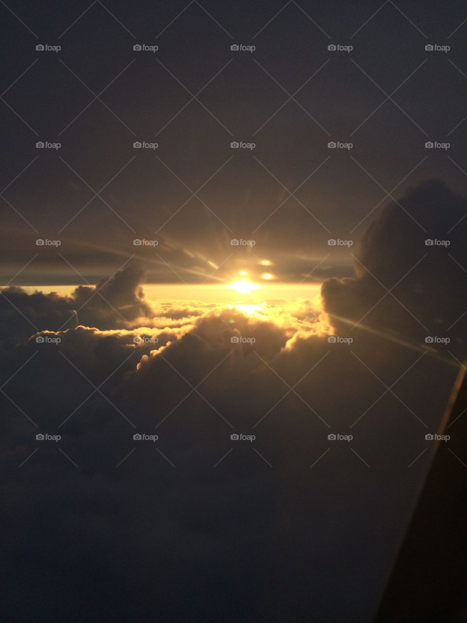 Spotted from an airplane. Fantastic sun rays glowing over the clouds like a glimpse of heaven. 