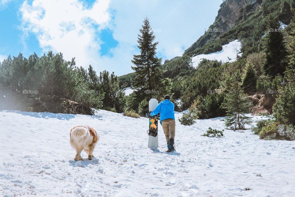 man snowboarding with his dog