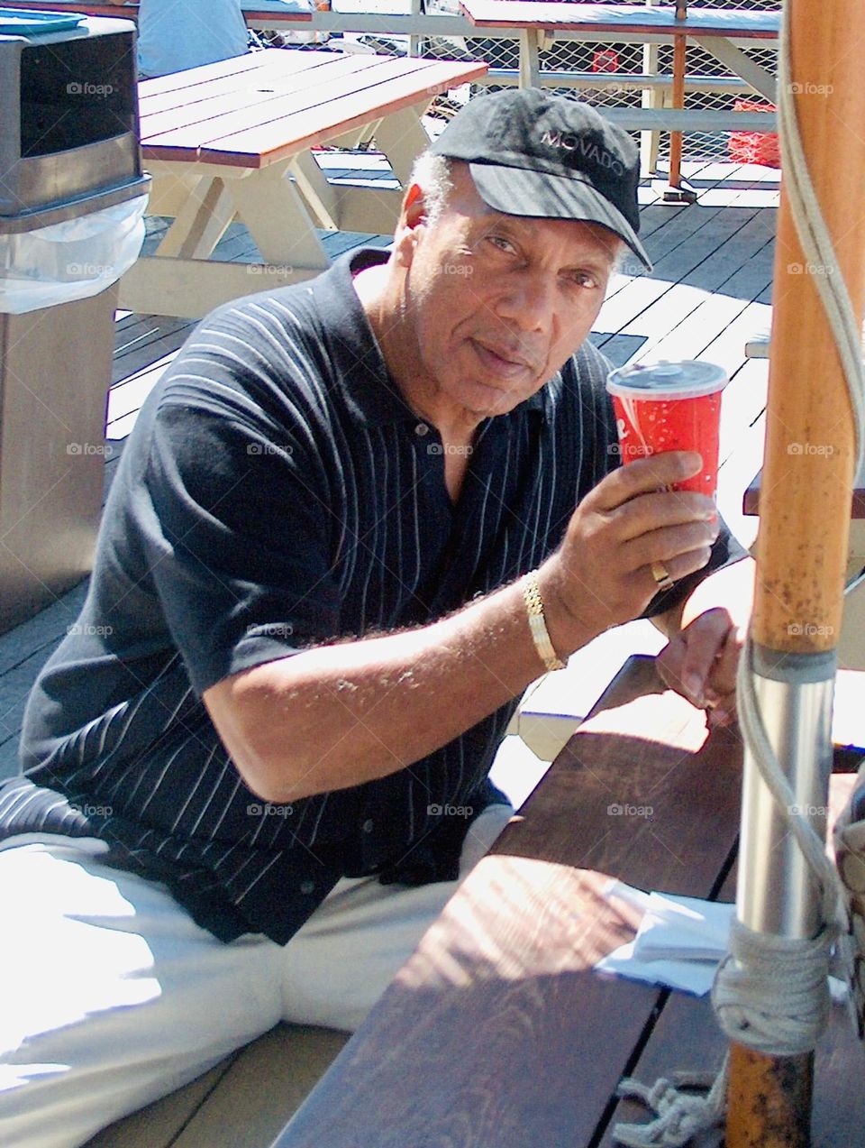 Senior man  having a drink at picnic, enjoying the day 