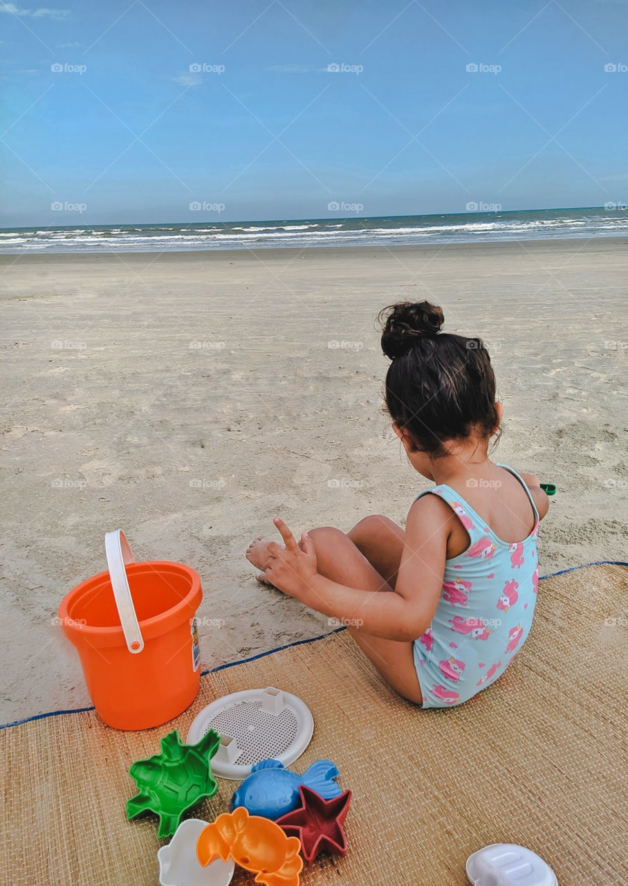 child playing in the sand on the beach