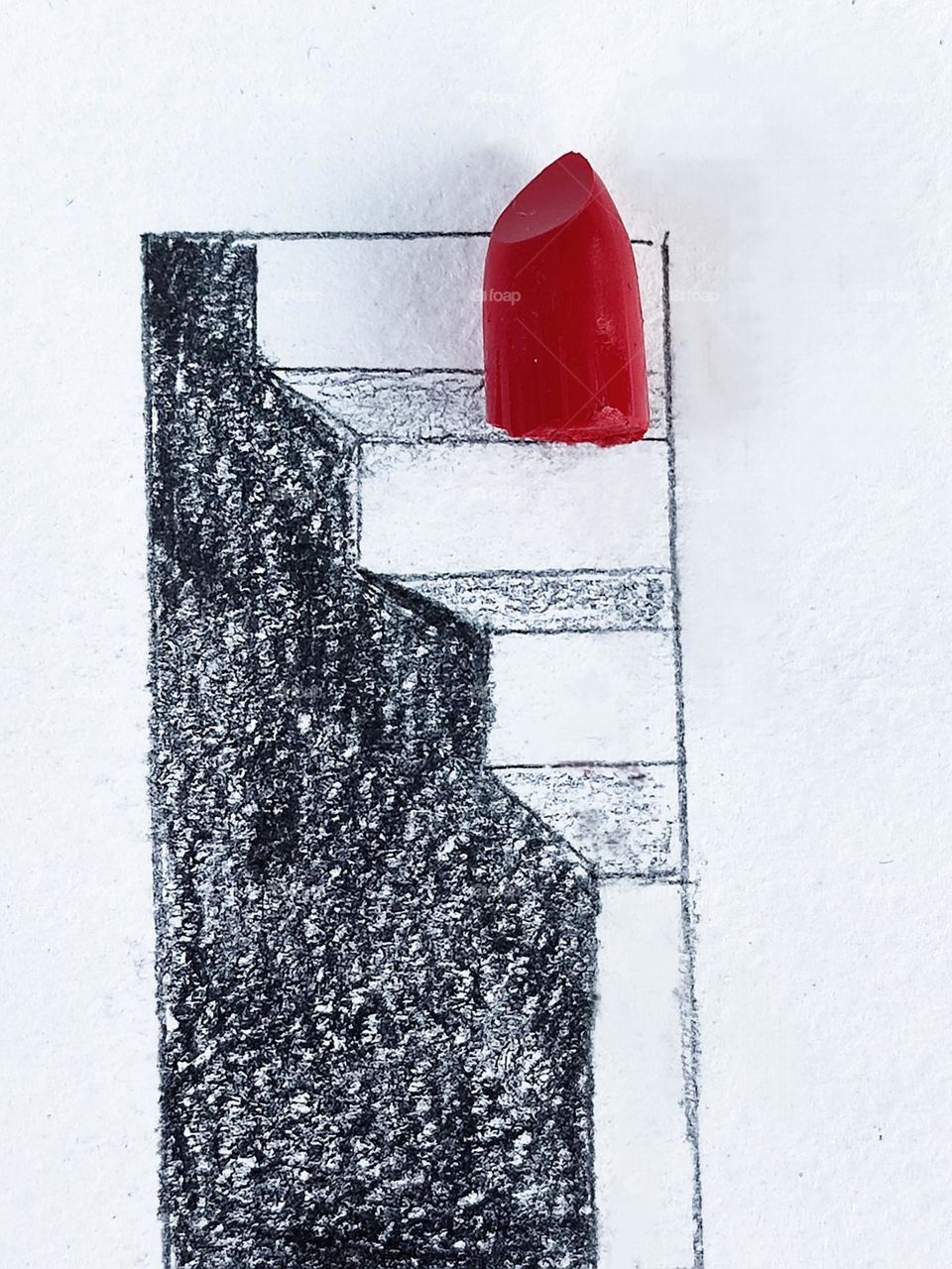 A white sheet of paper on which a 3-d drawing of a staircase is drawn with a black pencil.  There is a piece of red lipstick on the stairs.  Contrast