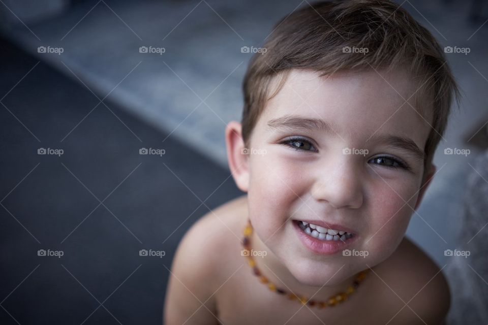 Boy smiling upwards at camera