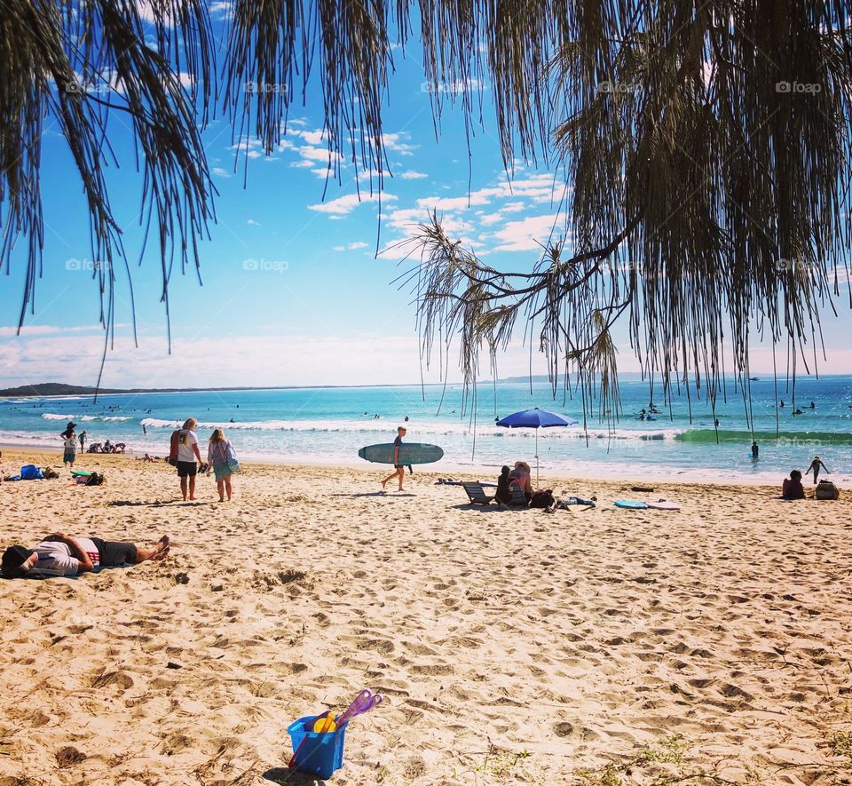 Blue umbrella blue bucket blue surfboard on the beach 
