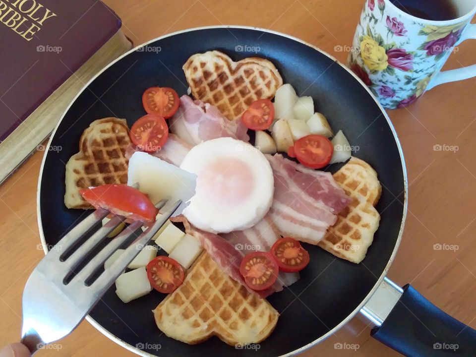 Delicious Hot Breakfast in Pan with Cup and Bible