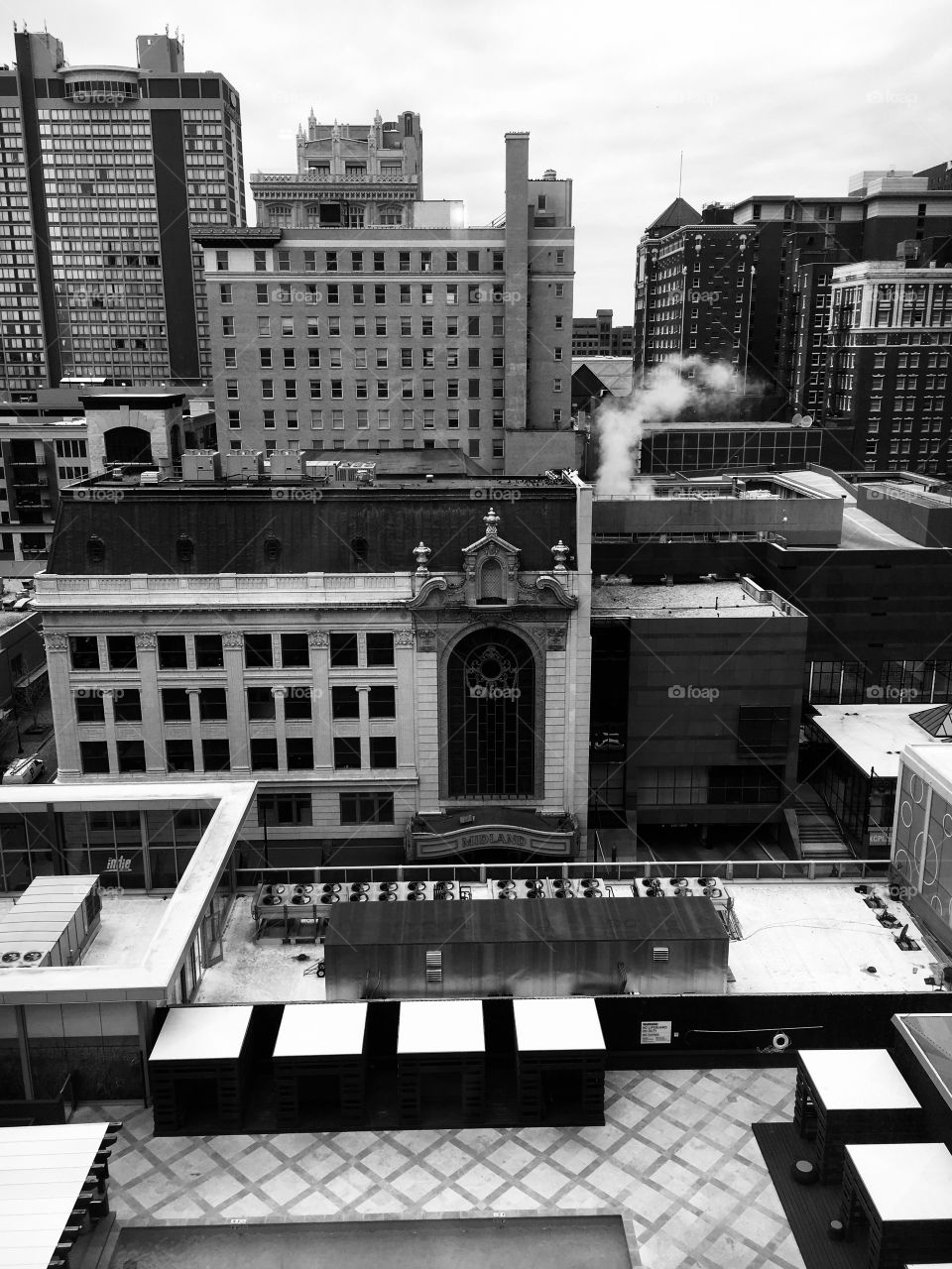 Mainland theater in downtown KC. Overlook of the city. Overcast, cool day. Has a Gotham look. 