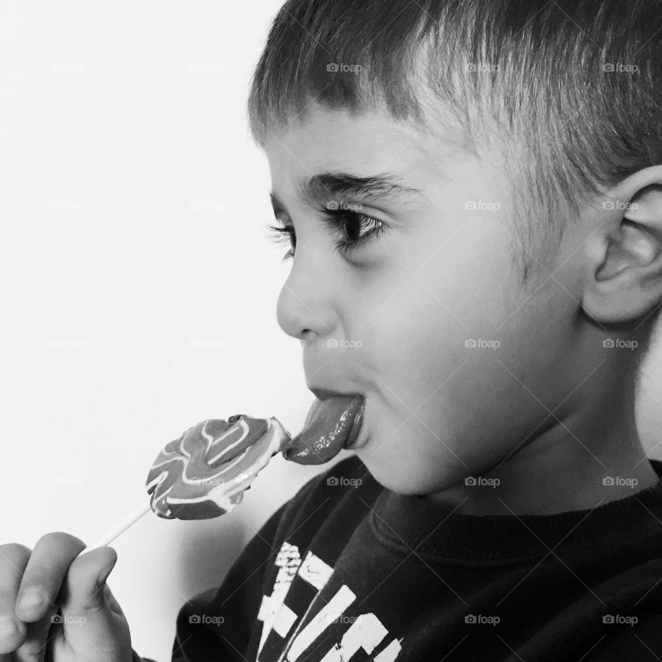 Little boy eating lollipop candy