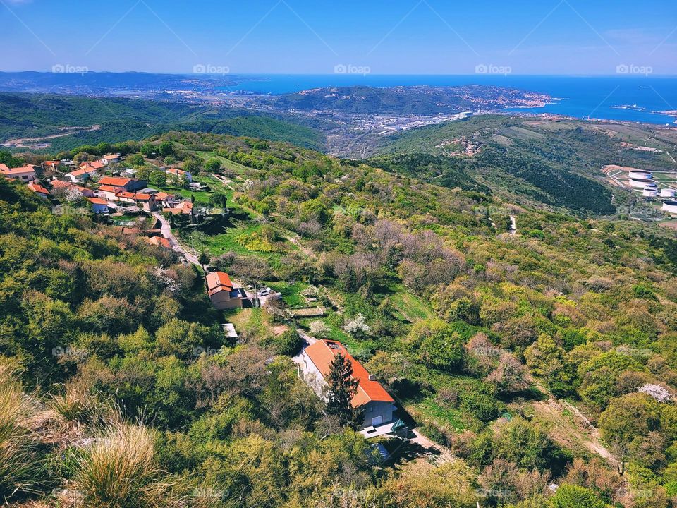 Scenic view of green hills against blue sky and Adriatic sea in Slovenia coast. Spring time