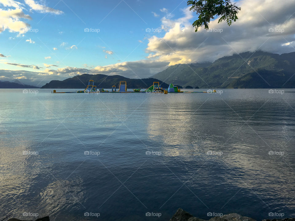 Reflections on a mountain lake at dusk, floating water park