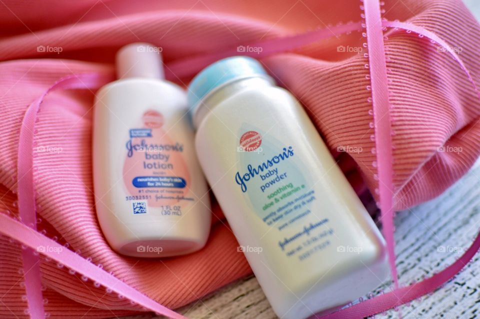 Johnson and Johnson baby lotion and powder with a pink ribbon and white background
