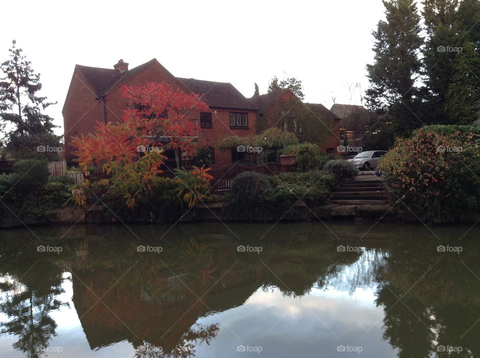 The reflection of building, sky and trees in the water in Stratford upon Avon