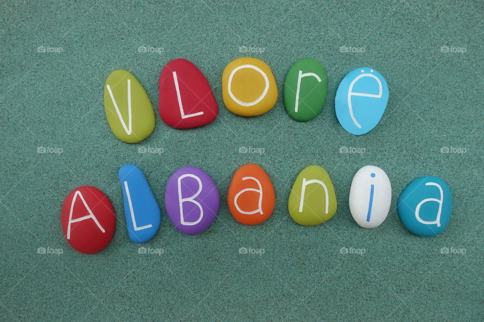 Vlore, souvenir of the touristic city of Albania with colored stones over green sand