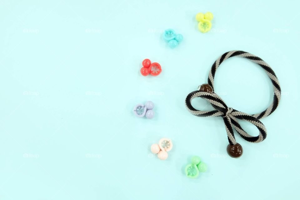 Brown Hair Rubber Band with Pearl Fashion Accessories. Top View. Rubber Band with Colorful Hair Clip Isolated on Blue Background Great for Any Use.