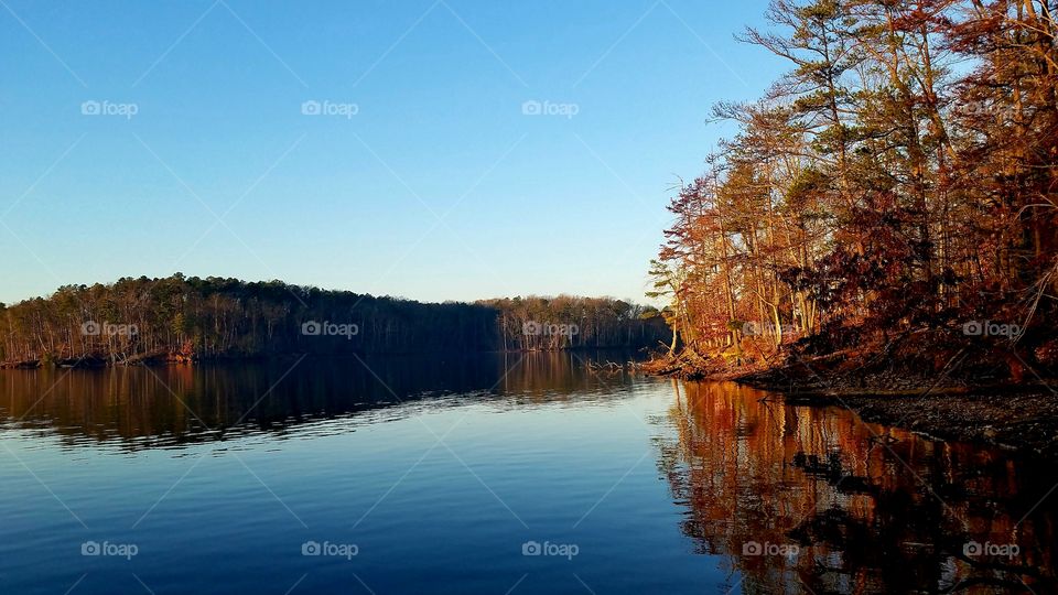 island and shore, reflections on lake.