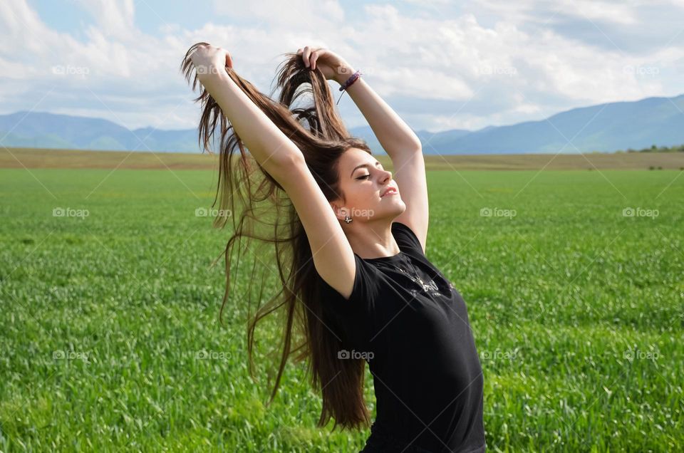 Woman with beautiful natural hair on green field background