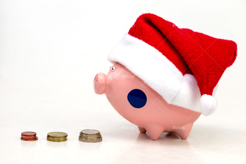 piggy bank in red cap Santa Claus and a stack of coins