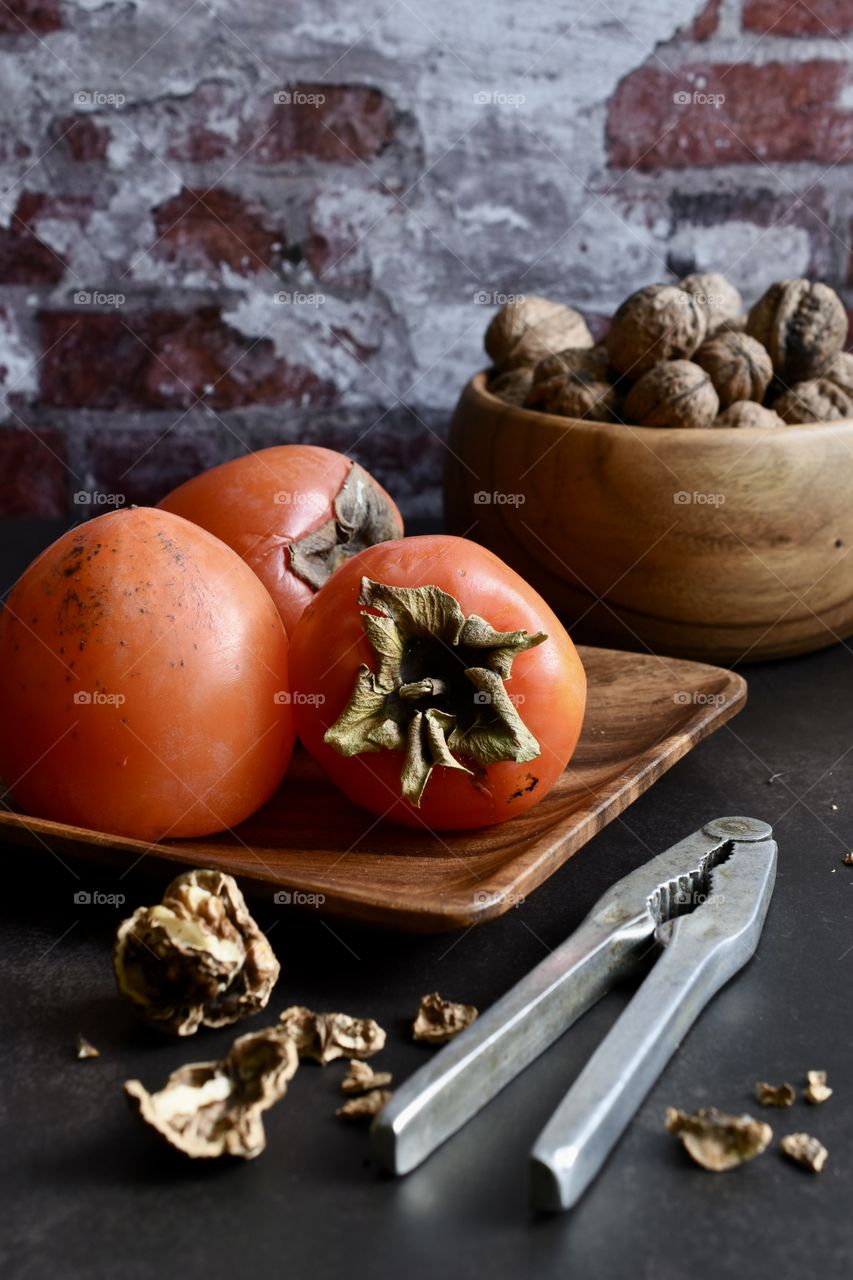 Persimmon and nuts on a table 