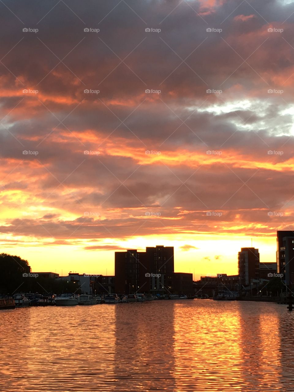 Sunset over Brayford Pool in Lincoln with multicoloured clouds and cityscape silhouette 
