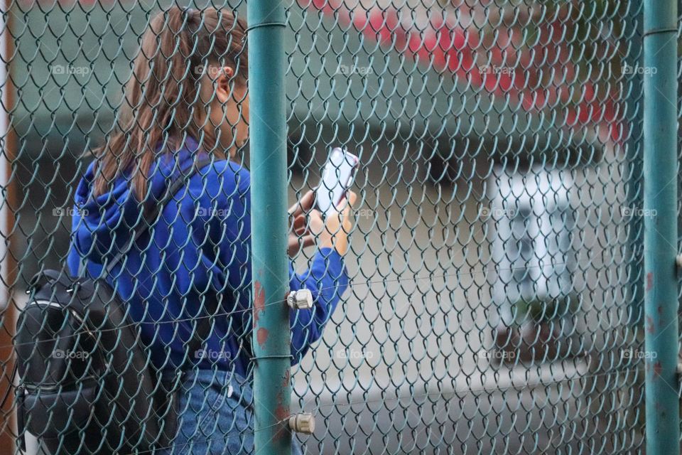 Photo of a girl over a metal fence