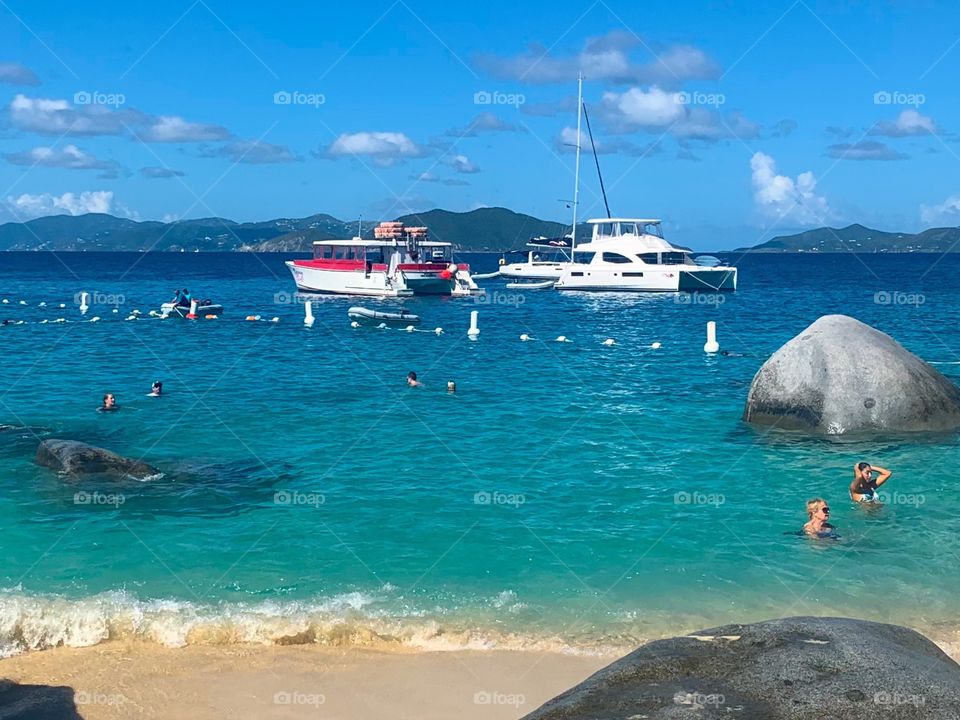 People in the water and on boats in the ocean water at summer