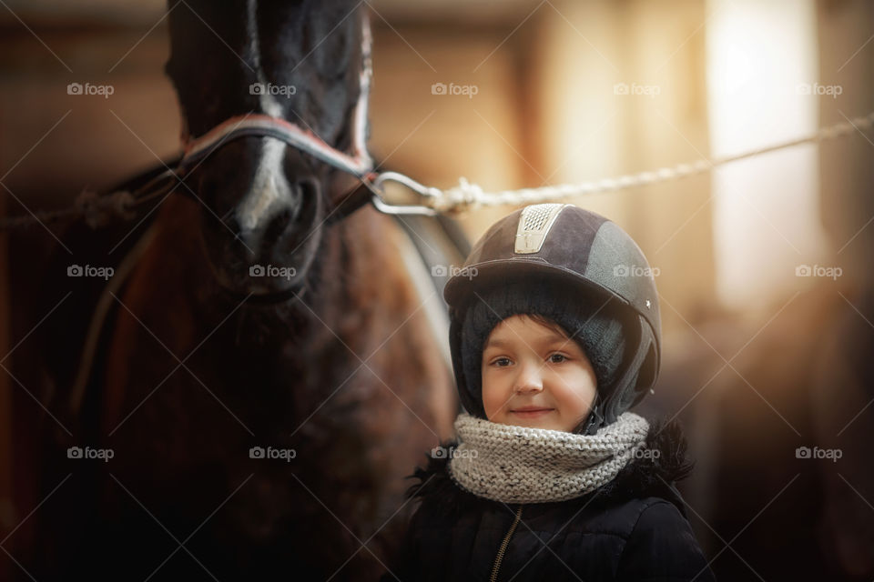 Girl in horse riding wear in a stable