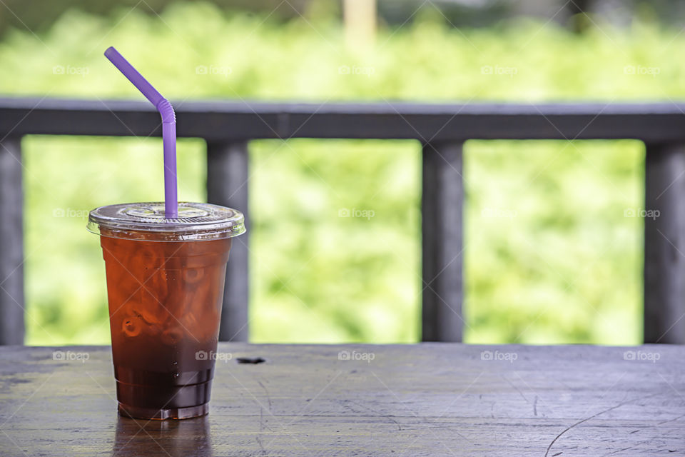 Iced tea in a glass on the wooden table.