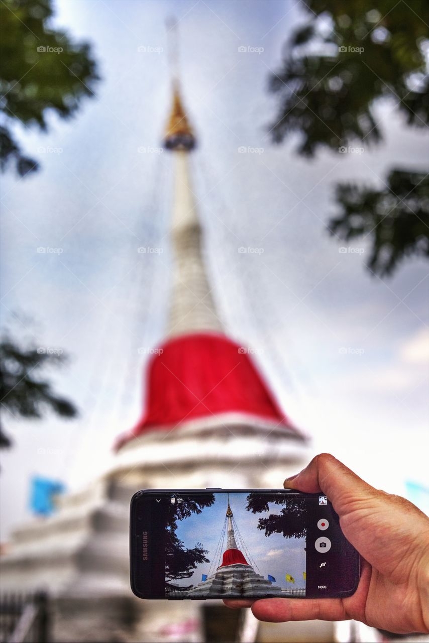 mobile phone framing the stupa of chedi in buddhist temple in Bangkok Thailand