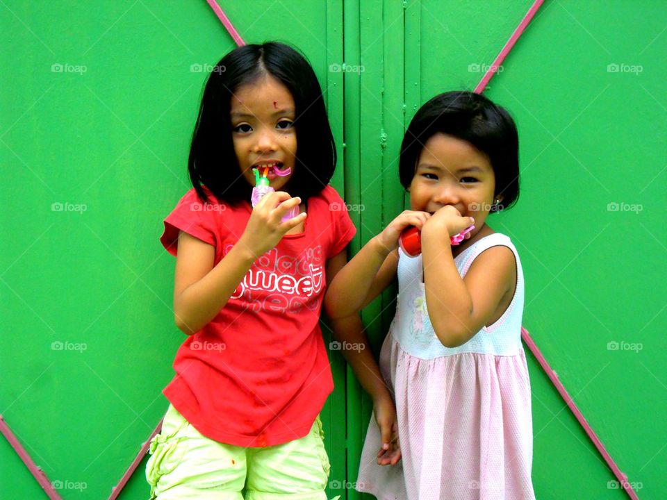 young asian girls smiling and playing with toy bubble maker