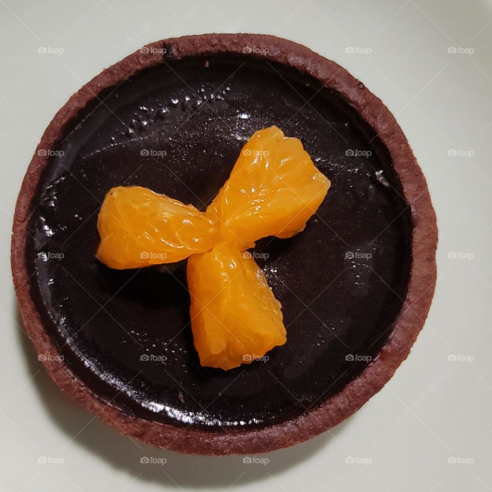 Chocolate tart with orange wedges